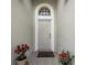 Welcoming front entryway featuring a tiled floor, neutral color palette, decorative plants, and a transom window at 29542 Forest Glen Dr, Wesley Chapel, FL 33543