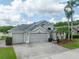 Charming single-Gathering home featuring tropical landscaping, a three-car garage, and a well-maintained lawn at 29542 Forest Glen Dr, Wesley Chapel, FL 33543