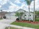 Beautiful single-Gathering home featuring tropical landscaping, a three-car garage, and a well-maintained lawn at 29542 Forest Glen Dr, Wesley Chapel, FL 33543