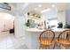 Bright kitchen features breakfast bar, white countertops and cabinets, stainless refrigerator, and tile floors at 29542 Forest Glen Dr, Wesley Chapel, FL 33543