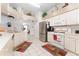 Bright kitchen features white appliances, tile floors, and tiered design with a view into dining area at 29542 Forest Glen Dr, Wesley Chapel, FL 33543