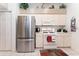 Bright kitchen features stainless refrigerator, white appliances and cabinets, and tile floors at 29542 Forest Glen Dr, Wesley Chapel, FL 33543