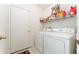 Functional laundry room featuring a washer, dryer, storage shelving, and tile floors at 29542 Forest Glen Dr, Wesley Chapel, FL 33543