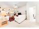 Bright living room with white furniture, red pillows, ceiling fan and view into the kitchen and hallway at 29542 Forest Glen Dr, Wesley Chapel, FL 33543