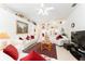 Bright living room with white furniture, red pillows, ceiling fan and view into the kitchen at 29542 Forest Glen Dr, Wesley Chapel, FL 33543