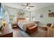 Cozy bedroom with hardwood floors, a ceiling fan, and natural light from multiple windows at 3008 N 13Th St, Tampa, FL 33605