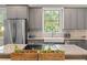 Updated kitchen with stainless steel appliances, a farmhouse sink, and natural light streaming through the window at 3008 N 13Th St, Tampa, FL 33605