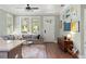 Well-lit living room featuring a sectional sofa, hardwood floors, and stylish decor, seamlessly flowing into the kitchen at 3008 N 13Th St, Tampa, FL 33605
