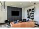 Comfortable lounge area with a leather sofa, a television, and contemporary decor, ideal for relaxation at 31356 Pendleton Landing Cir, Wesley Chapel, FL 33545
