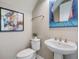 Powder room featuring a pedestal sink, toilet, and decor accents for a stylish and functional space at 3303 Monroe Meadows Dr, Odessa, FL 33556
