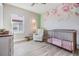 Light and airy bedroom with hardwood floors, a cozy armchair and a floral wallpaper wall at 3303 Monroe Meadows Dr, Odessa, FL 33556