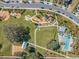 Aerial view of a community park with a modern playground, pool, and recreational area at 3303 Monroe Meadows Dr, Odessa, FL 33556