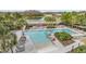 A large community pool with lounge chairs, palm trees and green landscaping in a beautiful neighborhood at 3303 Monroe Meadows Dr, Odessa, FL 33556