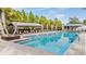 Spacious pool area featuring ample seating and a large pool, surrounded by lush landscaping and shaded cabanas at 3303 Monroe Meadows Dr, Odessa, FL 33556
