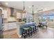 Spacious kitchen island with barstool seating and stone countertops complements open floor plan with dining area at 3303 Monroe Meadows Dr, Odessa, FL 33556
