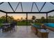 Inviting outdoor seating area with comfortable wicker furniture overlooking serene sunset views at 3303 Monroe Meadows Dr, Odessa, FL 33556