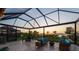 Relaxing screened patio boasts comfortable seating and views of the sunset over the water at 3303 Monroe Meadows Dr, Odessa, FL 33556