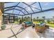 This cozy screened patio is perfect for enjoying the outdoors with comfortable seating and shade at 3303 Monroe Meadows Dr, Odessa, FL 33556