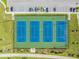 Aerial view of four brightly painted blue and green tennis courts ready for a match at 3303 Monroe Meadows Dr, Odessa, FL 33556
