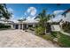 Well-maintained property showcasing paver driveway, lush landscaping, solar panels, and fenced yard at 333 Belleair Ne Dr, St Petersburg, FL 33704