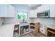Renovated kitchen boasts white cabinetry, marble countertops, stainless steel appliances, and a garden window at 333 Belleair Ne Dr, St Petersburg, FL 33704