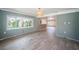 Inviting living room featuring wood-look flooring, shiplap accents, and natural light from multiple windows at 333 Belleair Ne Dr, St Petersburg, FL 33704