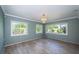 Cozy living room with shiplap walls, wood-look floors, a decorative chandelier, and sunlit windows at 333 Belleair Ne Dr, St Petersburg, FL 33704