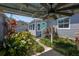 Back yard featuring covered patio, lush landscaping and a quaint, cottage-style exterior at 3422 W San Pedro St, Tampa, FL 33629