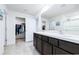 Bathroom featuring double sinks, a large mirror, and a walk-in closet at 36398 Spanish Rose Dr, Dade City, FL 33525