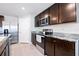 Modern kitchen featuring dark cabinets, stainless steel appliances, and granite countertops at 36398 Spanish Rose Dr, Dade City, FL 33525