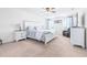 Bright primary bedroom featuring a large bed, ceiling fan, and abundant natural light through windows at 36398 Spanish Rose Dr, Dade City, FL 33525
