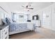 A bright bedroom with a ceiling fan, a large bed, and a doorway to the en-suite bathroom at 36398 Spanish Rose Dr, Dade City, FL 33525