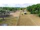Aerial view showcasing the rural property with its barn-style home, trailer, and ample fenced land at 36601 Roberts Rd, Dade City, FL 33525