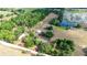 A beautiful aerial view shows the expansive acreage with multiple buildings and a serene pond at 36601 Roberts Rd, Dade City, FL 33525