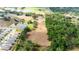 Aerial view showcasing the property's boundaries near a pond, with adjacent neighborhood, and plentiful trees at 36601 Roberts Rd, Dade City, FL 33525