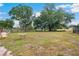 Large backyard features plenty of space and mature trees, perfect for outdoor activities at 36601 Roberts Rd, Dade City, FL 33525