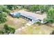 Aerial view of an outdoor pool and patio, complete with ample yard space and mature trees at 36601 Roberts Rd, Dade City, FL 33525