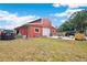 Large red barn with a garage door, surrounded by a well-maintained yard and machinery on the side at 36601 Roberts Rd, Dade City, FL 33525