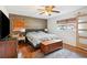 Comfortable bedroom featuring a wooden accent wall, a large bed, and natural light from the window at 36601 Roberts Rd, Dade City, FL 33525