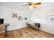 Bright room with wood floors, windows, ceiling fan, and a massage table at 36601 Roberts Rd, Dade City, FL 33525