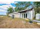 Exterior view of the outbuilding with white and metal walls, with two doors, and garage door, and a metal roof at 36601 Roberts Rd, Dade City, FL 33525