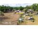 Aerial view displays the property with its barn-style home, trailer, and lush rural landscape at 36601 Roberts Rd, Dade City, FL 33525