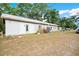 Exterior view of the outbuilding with white walls, a metal roof, and natural light from windows and doors at 36601 Roberts Rd, Dade City, FL 33525
