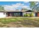 Quaint one story home featuring a manicured lawn, mature landscaping, and a brick-lined entryway at 36601 Roberts Rd, Dade City, FL 33525