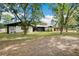 Lovely house displaying a vast front lawn, mature trees, and an attached garage with an extended driveway at 36601 Roberts Rd, Dade City, FL 33525