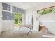 Under-construction room featuring bare walls, large windows, a glass door, and a table in the center at 36601 Roberts Rd, Dade City, FL 33525