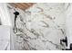 Close-up of a shower with marble tiling and a black shower head at 36601 Roberts Rd, Dade City, FL 33525