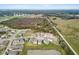 Community aerial view highlighting new construction homes in a scenic area with nearby fields and a pond, showing its location at 38190 Shale Stone Ct, Zephyrhills, FL 33540