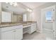 Bright bathroom with granite countertops, double sinks, and white cabinetry at 38190 Shale Stone Ct, Zephyrhills, FL 33540