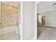 Bathroom featuring tub and neutral-colored tile and a view of a bedroom at 38190 Shale Stone Ct, Zephyrhills, FL 33540